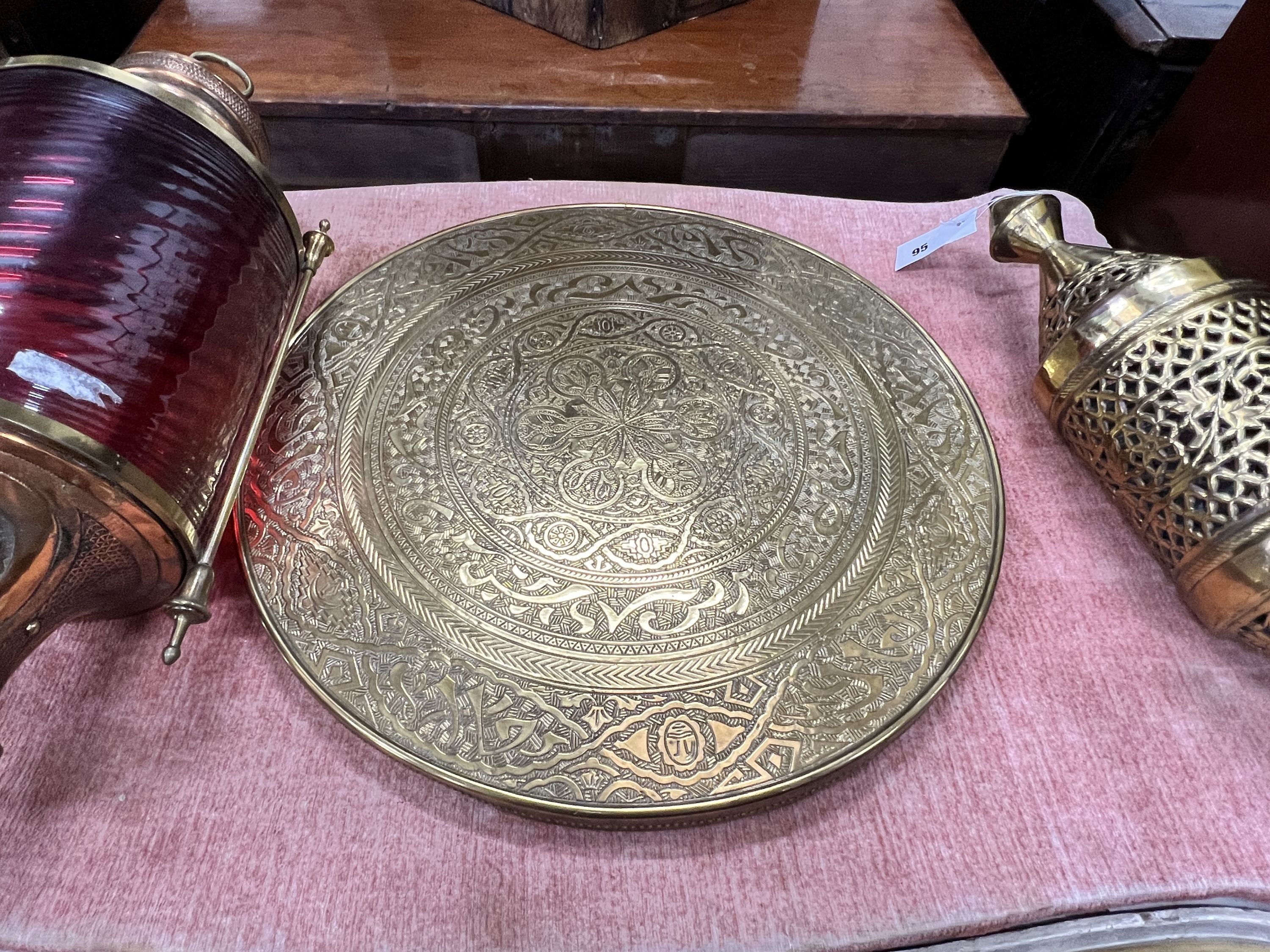 A copper and ruby glass lantern, height 70cm, a Moorish brass lantern, height 52cm and a Benares brass table top